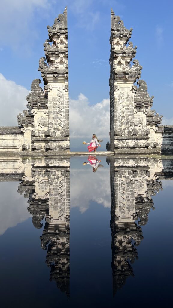 a Black woman with blonde braids kneeling at Lempuyang Temple