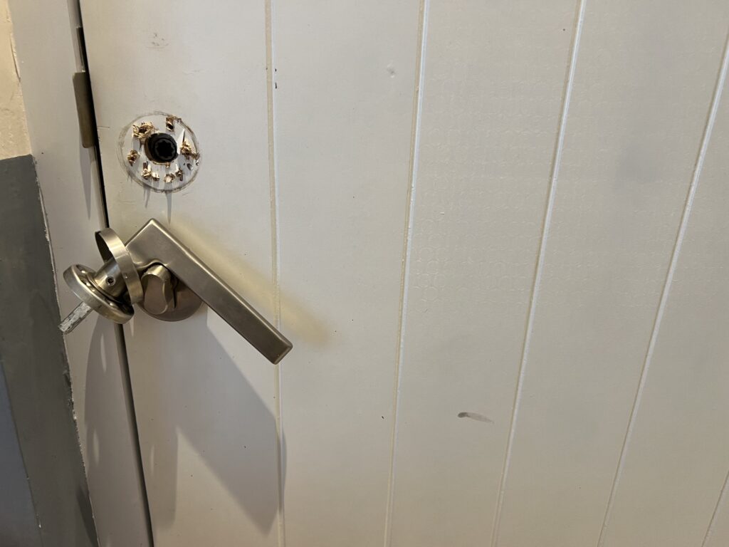 a broken door handle, dirty walls with black stains