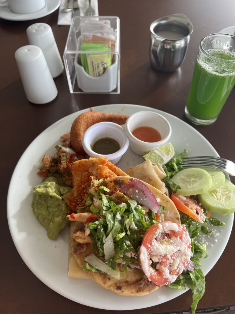 a plate of mexican  food and a green fresh fruit juice