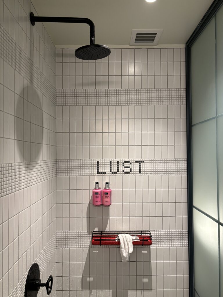 standup shower that says "lust" at Moxy NYC Chelsea hotel