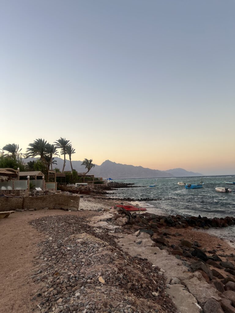 a Beach in Dahab around sunset with mountains in the background