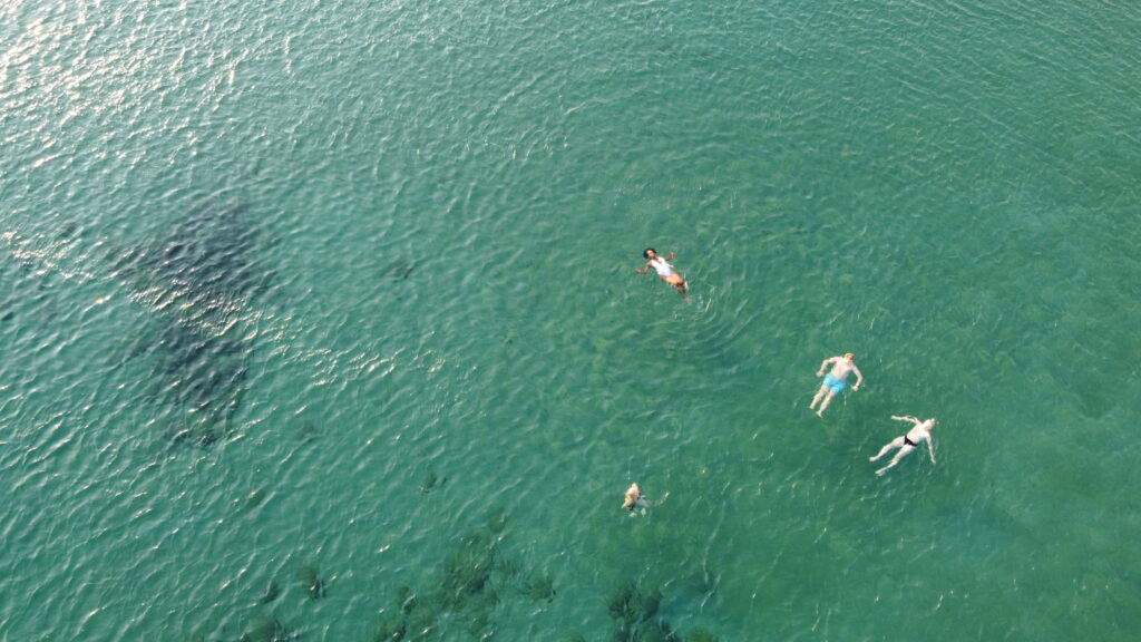 drone footage of people swimming at Sounio Beach