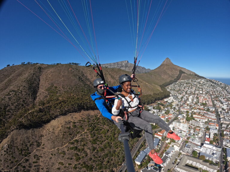 A dark skinned Black woman paragliding in Cape Town