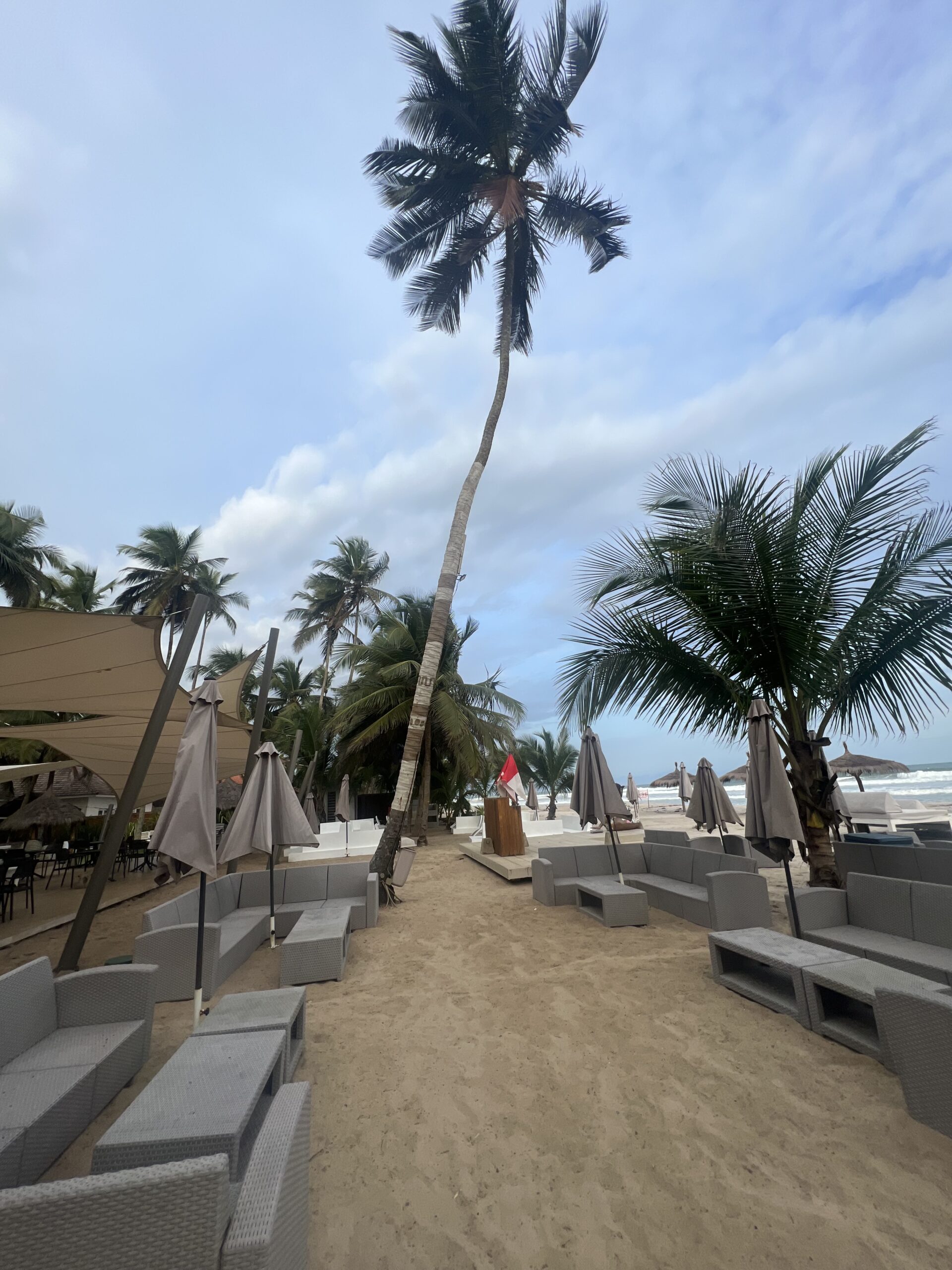 chairs, sofas, and palm trees on the beach front in Assinie Mafia