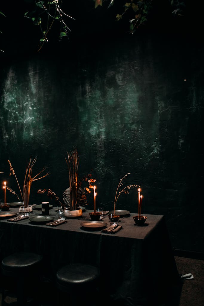 Creative interior of cafe with burning candles and dried plants on festive table