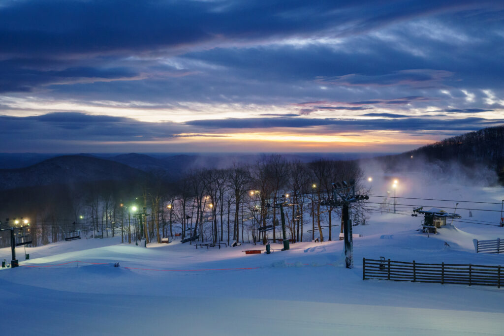 Winter sunrise at a ski resort, with mountains in background