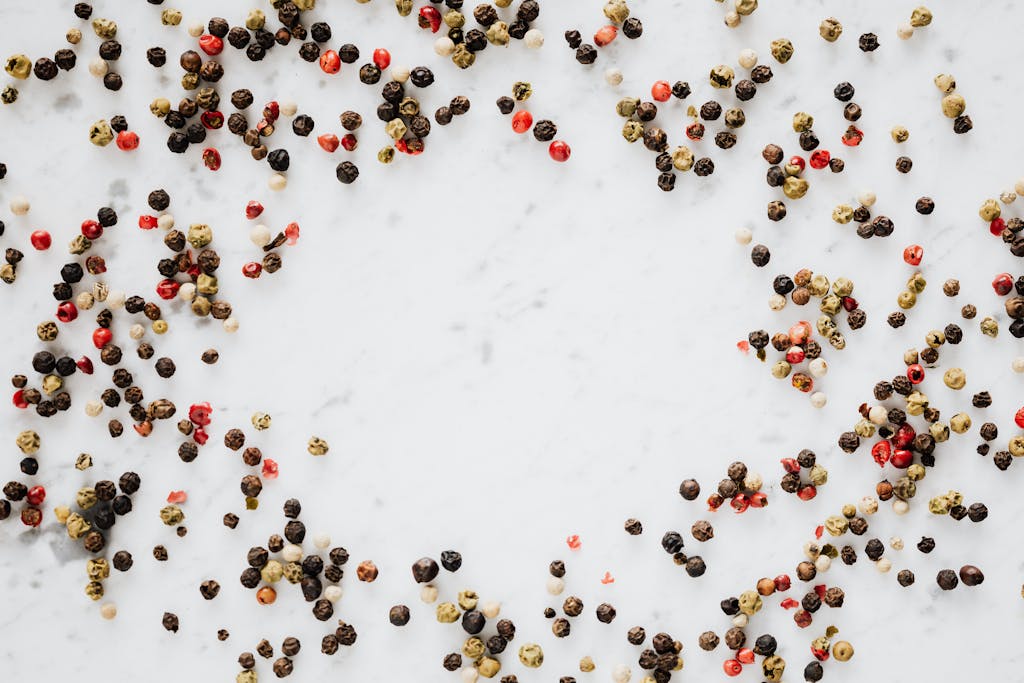 Assorted pepper spilled on white table