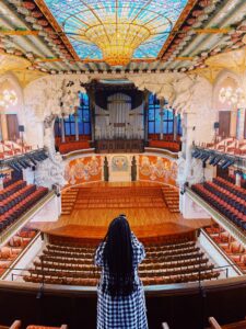 a Black woman with long braids in the cinter of Guide to Barcelona's Palau de la Musica Catalana in Barcelona