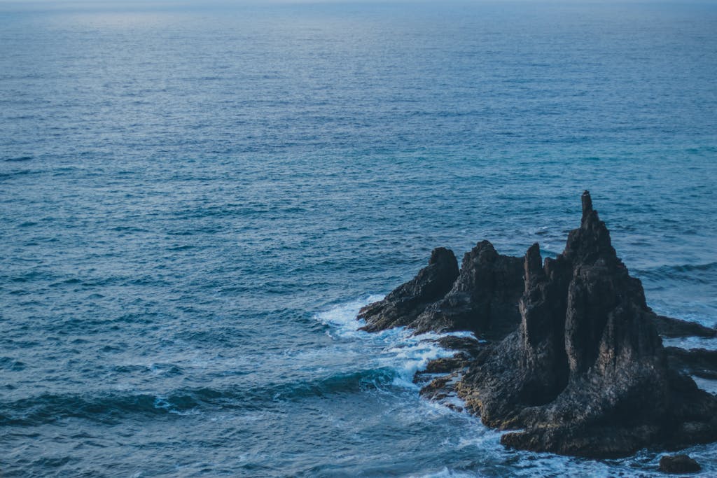 Explore the dramatic rock formations on the sea in Tenerife during twilight.