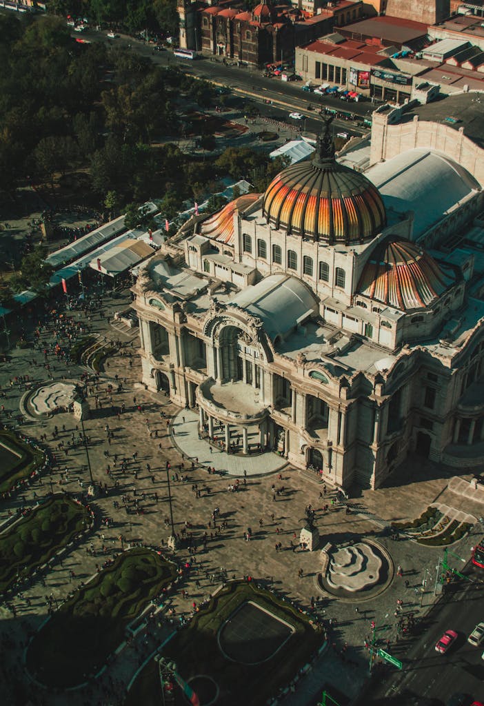 Stunning aerial shot of the iconic Palacio de Bellas Artes in Mexico City, showcasing its vibrant dome and historic architecture.