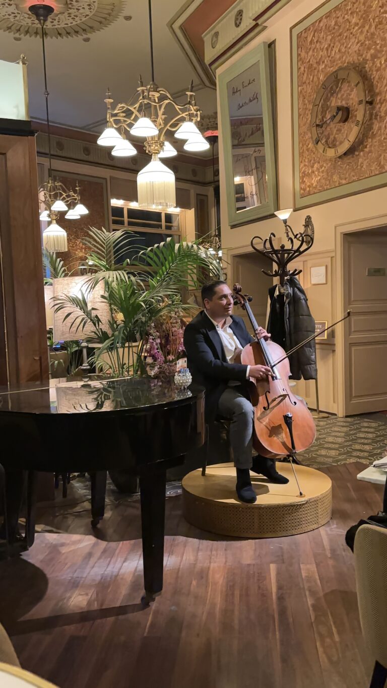 a man playing a guitar at Central Grand Café in Budapest, one of the best cafes in the Budapest.